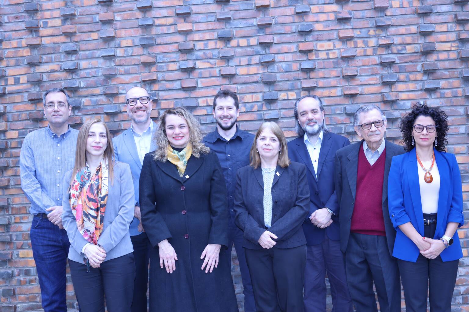 Fotomontaje de los nueve integrantes de INDEX frente a un muro de ladrillo